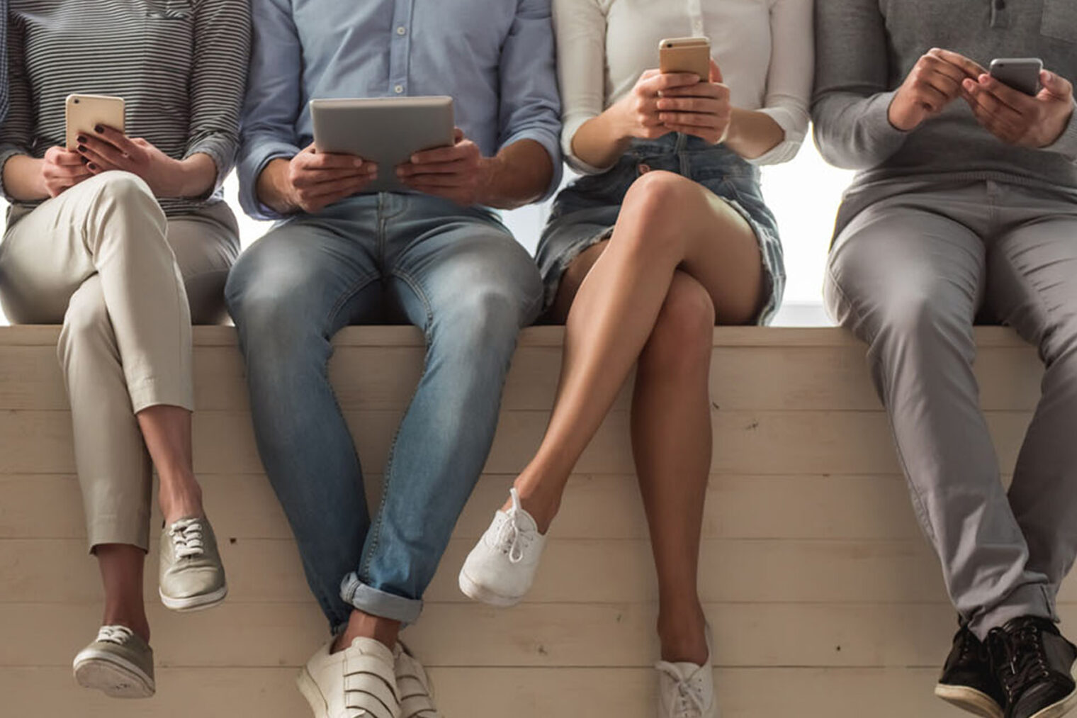gruppe mit handy sitzend auf mauer